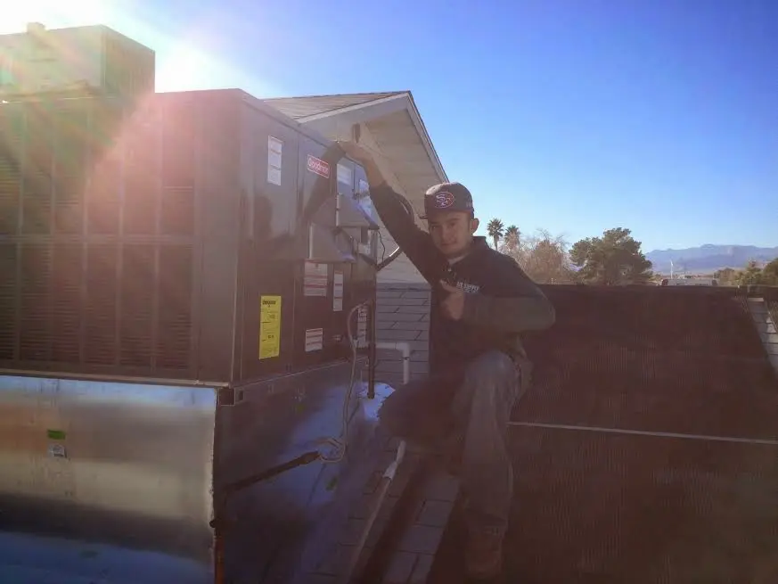 HVAC technician performing Heat Pump Repair on a rooftop unit in Shrewsbury